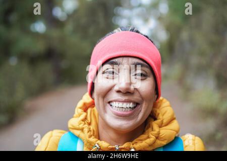 Portrait einer lateinischen Frau, die sich während des Trekkingtages in den Wald amüsieren kann - Fokus auf Gesicht Stockfoto