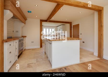 Newmarket, Suffolk, England - September 23 2019: Moderne Einbauküche in traditionellem Stil mit Eichen-Arbeitsplatten und Peninsula-Spüle. Stockfoto