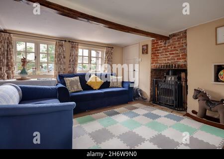 Hargrave, Suffolk, England - Juni 10 2020: Traditionelle englische Country Cottage Lounge oder Wohnzimmer mit gusseisernem Holzofen und niedriger Decke Stockfoto