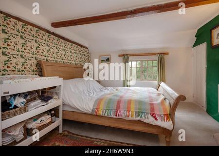 Hargrave, Suffolk, England - Juni 10 2020: Traditionelles englisches Landhaus-Schlafzimmer mit freiliegenden Balken, kleinen Fenstern und niedriger Decke. Stockfoto