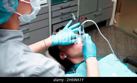Nahaufnahme einer Zahnärztin, die an einer jungen Patientin in einer Zahnklinik operiert Stockfoto