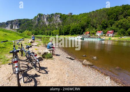 Elbe landschaftlich schöne Aussicht Deutschland Elbtal in der Sächsischen Schweiz Menschen an Land beobachten vorbeifahrende Boote und Sandsteinfelsen Stockfoto