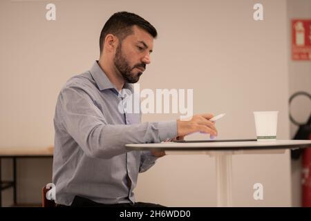 Junger attraktiver Geschäftsmann, der mit Tablet und Mobiltelefon arbeitet. Stockfoto