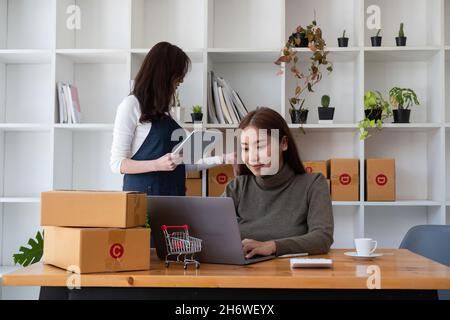 Zwei asiatische Frauen arbeiten zusammen für KMU-Projekt. Young Owner People Startup für Business Online, SME, Delivery Project. Online-Geschäftskonzept Stockfoto