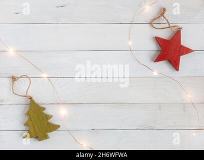 Neujahr Baumschmuck aus Holz und Girlande auf dem weißen Holzhintergrund, Draufsicht, Kopierraum Stockfoto