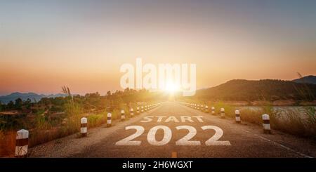 Neues Jahr 2022 geschrieben auf Autobahn Straße. Leere Asphaltstraße und schöner Sonnenaufgang Himmel Hintergrund. Ziel- und Challenge-Konzept für Vision 2022. Stockfoto