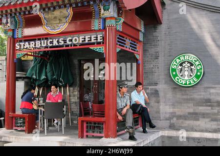 Peking, China. August 2008. Ein Polizeibeamter sitzt unter den Gästen in einem Starbucks-Café am Houhai Lake. Das Hutong-Viertel in Houhai ist ein beliebtes Ausgehviertel mit vielen Restaurants, Bars und Cafés; das Viertel ist besonders bei Touristen, „Expats“ und hippen Einwohnern Pekings beliebt. Quelle: Stefan Jaitner/dpa/Alamy Live News Stockfoto