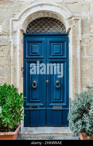 Malta ist die Heimat von erstaunlich einzigartigen Türen.traditionelle bunte maltesische Tür in Valletta.Haustür zu Haus aus Malta.Blaue Holztür und Steinfassade Stockfoto
