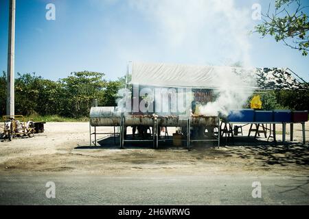 Huhn und Würstchen werden in improvisierten Grills aus Fässern gebraten. Dies kann in den armen Gebieten von Cancun gefunden werden, die als Regionen bezeichnet werden. Cancun, ein weltbekannter Touristenort, ist eine Küstenstadt im östlichsten Bundesstaat Mexikos, Quintana Roo, auf der Halbinsel Yucatan. Gegründet nicht mehr als 30 Jahre, die Stadt Häuser über 500,000 Menschen, die hierher kamen aus verschiedenen Teilen von Mexiko und der Welt, mit dem Traum von einem besseren Leben. Dies ist ein genauerer Blick oder eine persönlichere Ansicht von Cancun, die seine Menschen und Tourismus zeigt, die Unterschiede und Gleichheit, Vermischung und Homogenisierung von zwei völlig verschiedenen Kulturen su Stockfoto