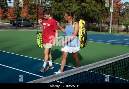 Perry, Georgia, USA. November 2021. Anna lange spricht mit dem Teenager-Sohn Riley bei einem Tennistragen in der Nähe ihres Hauses. Der Ermittler der Sheriff-Abteilung im Houston County ist dankbar für den jährlichen Transgender Day of Remembrance, der am 20. November begangen wurde. Lange, 49, kämpfte jahrzehntelang mit ihrer Geschlechtsidentität und gab zu, wer sie wirklich war. Sie wurde in den Rang eines Sergeanten befördert und wird von ihren Gleichaltrigen respektiert, die zugaben, dass sie noch nie zuvor eine Transgender-Person getroffen hatten. Sie begann ihren Übergang im Jahr 2018 und die countyÃs-Versicherung hatte ihre Geschlechtsbestätigung genehmigt, aber dann lehnte sie ab Stockfoto