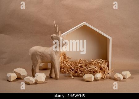 Minimales Öko Weihnachtskonzept. Haus und Hirsch aus Holz und Papier. DIY Bio nachhaltige Weihnachtsdekoration. Stockfoto