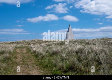 Der Emmanuel Head Beacon ist eine Navigationshilfe, die 1810 auf der britischen Insel Holy Island gebaut wurde. In einer natürlichen Umgebung stehend, hat es ein surreales Aussehen. Stockfoto