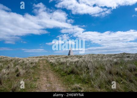 Der Emmanuel Head Beacon ist eine Navigationshilfe, die 1810 auf der britischen Insel Holy Island gebaut wurde. In einer natürlichen Umgebung stehend, hat es ein surreales Aussehen. Stockfoto