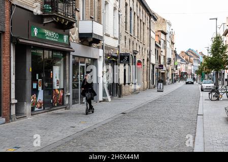 Vilvoorde, Flämische Region - Belgien - 10 17 2021: Junge Frau, die einen Schritt in die Einkaufsstraße fährt Stockfoto