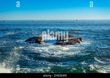 Schwarze Felsen im Ozean vor der Küste von Dana Point, Kalifornien Stockfoto