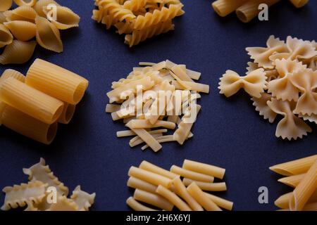 Verschiedene Arten von traditionellen italienischen Pasta auf dunklem Hintergrund Nahaufnahme Stockfoto