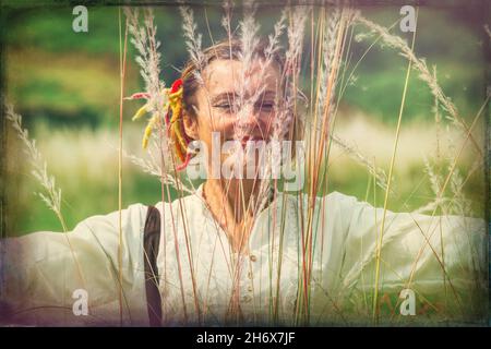 30-35-jährige Frau im Federgras in der Nähe des Flusses Stockfoto