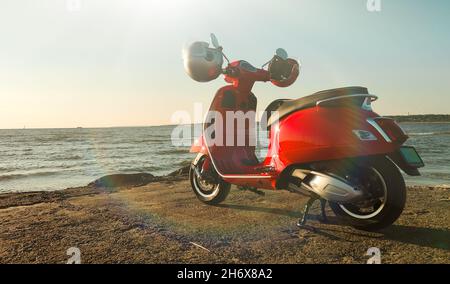 Roter Oldtimer-Roller an der Küste. Stockfoto