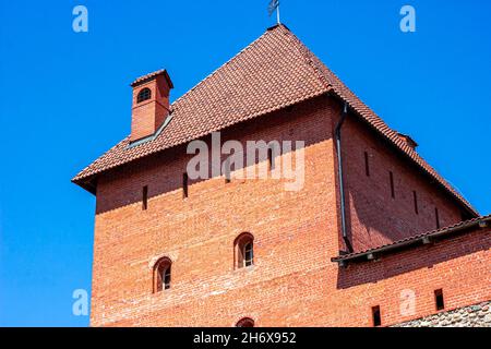 LIDA, WEISSRUSSLAND - 10. JULI 2021: Archäologisches Denkmal mittelalterlicher Stein und Ziegel Lida Burg, historischer Schauplatz für Touristen gegen den blauen Himmel in Stockfoto