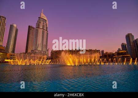 DUBAI, VAE - 3. MÄRZ 2020: Die große beleuchtete Fountain Show und der lila Himmel des Dämmerungshimmels, am 3. März in Dubai Stockfoto