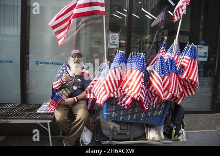 2021 Veterans Day Parade entlang der 5th Avenue. In New York City findet die größte Veterans Day Parade des Landes statt. Straßenverkäufer verkauft American Flags auf der 5th Avenue bei der Parade. Stockfoto