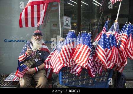 2021 Veterans Day Parade entlang der 5th Avenue. In New York City findet die größte Veterans Day Parade des Landes statt. Straßenverkäufer verkauft American Flags auf der 5th Avenue bei der Parade. Stockfoto