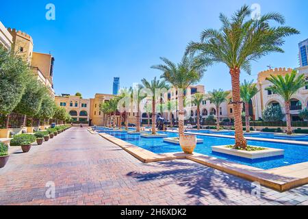 Der angenehme Innenhof mit einem Pool und Reihen von Palmen des Old Town Island Complex, Dubai, VAE Stockfoto