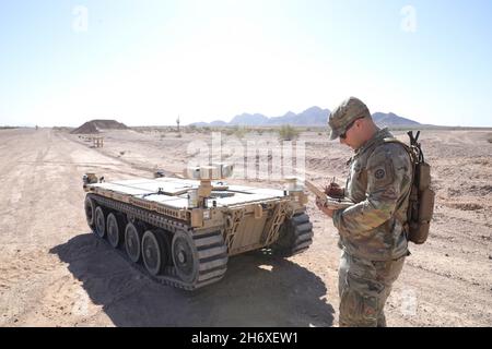 Usa. November 2021. U.S. Army PFC. Daniel Candales, der 82. Airborne Division zugeordnet, verwendet den taktischen Robotercontroller zur Steuerung des modularen autonomen Expeditionsfahrzeugs als Übungsübung zur Vorbereitung auf Project Convergence auf dem Yuma Proving Ground, Arizona, 19. Oktober 2021. Während des Projekts Convergence 21 experimentieren Soldaten damit, das Fahrzeug für die teilautonome Aufklärung und Nachversorgung zu verwenden. Project Convergence ist die Lernkampagne der Armee, die darauf ausgelegt ist, die Beiträge unserer Armee aggressiv zu fördern und zu integrieren, basierend auf einer kontinuierlich strukturierten Serie Stockfoto