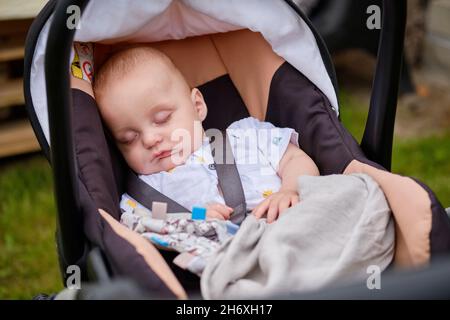 Nahaufnahme eines entzückenden Babys, das im Freien in einem Kinderwagen schläft Stockfoto