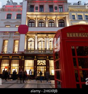 London, Greater London, England, 13 2021. November: Cartier festliche Fassade, während die Menschen in einer Schlange draußen auf der New Bond Street warten. Stockfoto