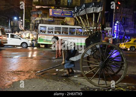 Kolkatas Rickshaw-Abzieher. Die dichte Metropole gehört zu den einzigen Orten in Indien – und zu den wenigen, die auf der Welt noch übrig sind – wo noch immer Flotten von handgezogenen Rikschas auf den Straßen unterwegs sind. Kalkutta, Indien. Stockfoto