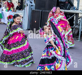 2021 19 09 Tulsa USA - schöne junge hispanische Mädchen tanzen auf dem Straßenfest in wunderschönen bunten Kleidern mit Blumen im Haar in der Schrift sta Stockfoto