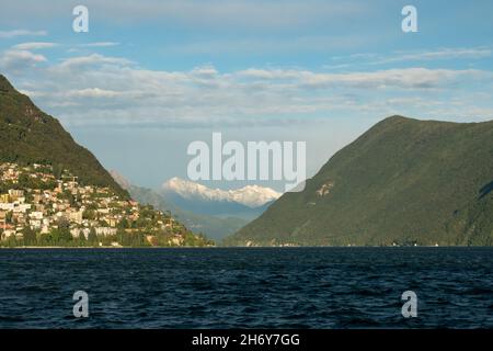 Lugano, Schweiz - 6th 2021. Oktober: Lago di Lugano mit umliegenden Hügeln und Bergen im Nachmittagssonne. Stockfoto