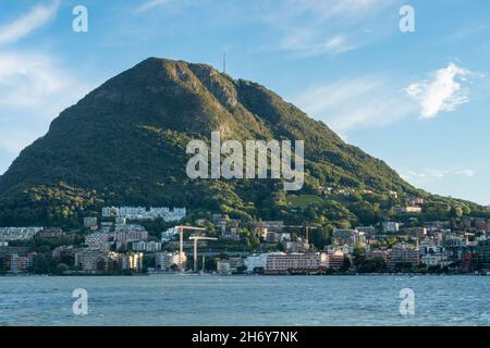 Lugano, Schweiz - Oktober 6th 2021: Skyline der Stadt mit dem berühmten Monte San Salvatore im Hintergrund Stockfoto