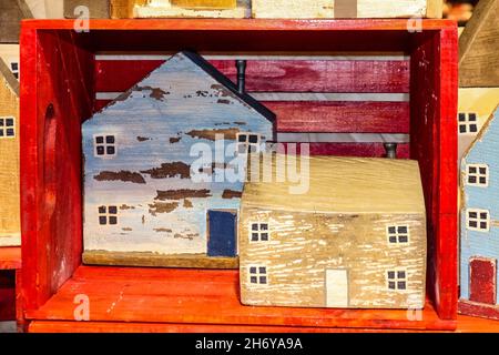 Rustikale, hausgemachte Holzblockhäuser, die in und um eine rote Holzkiste sitzen Stockfoto