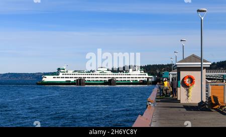 Edmonds, WA, USA - 17. November 2021; Washington State Car Ferry am Dock in Edmonds. Drei Fischer kontrollieren ihren Fang am Angelpier Stockfoto