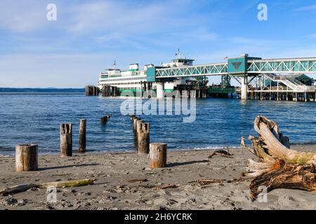 Edmonds, WA, USA - 17. November 2021; die Washington State Car Ferry Kaleetan dockte in Edmonds an. Am Strand befinden sich Treibholz und alte hölzerne Pfeiler. Stockfoto