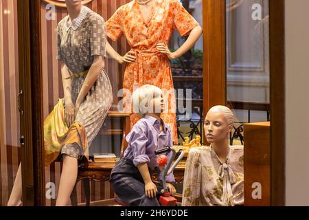 Frauen und Kinder Schaufensterpuppen in lässiger Retro-Kleidung auf dem Schaufenster des Bekleidungseinzelhandels im Einkaufszentrum. Stockfoto