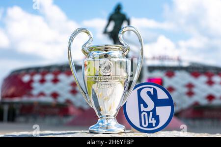 14. Juni 2021, Gelsenkirchen, Deutschland. Das Emblem des Fußballvereins FC Schalke 04 und des UEFA Champions League Cups vor dem Hintergrund eines Moders Stockfoto