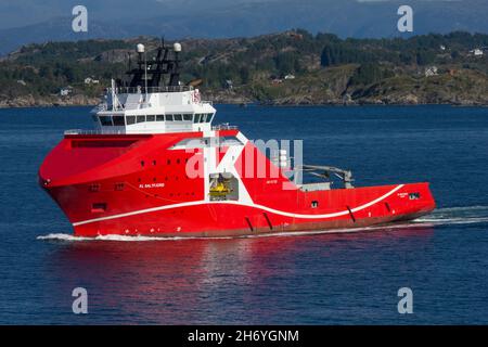 KL Saltfjord, Anchor Handling Schlepper Supply Vessel für 'K' Linie. Segeln von Bergen, Norwegen. Norwegische Küste und Berge im Hintergrund. Stockfoto