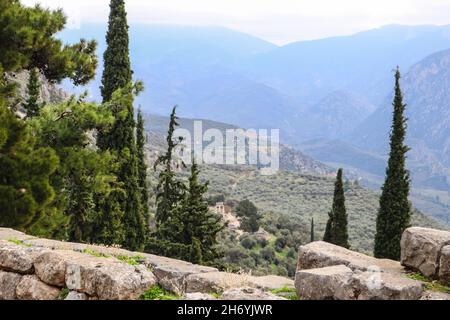 Blick von der archäologischen Stätte am Berghang des antiken Delphi Griechenland hinunter ins Tal und zum Tempel der Athene Stockfoto