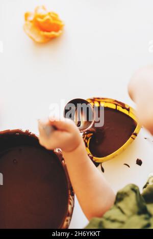 Das Kind bereitet zu Hause in der weißen Küche Schokoladenkekse zu. Weihnachts-Lebkuchen. Gelbe Silikon-Herzform. Stockfoto