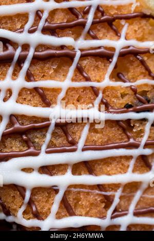 Nahaufnahme einer Schokoladenkuchen-Textur mit weißen und braunen Linien von Creme Stockfoto