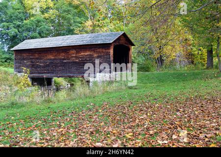 Cooperstown, New York, USA. Eine frühe Herbstansicht der Hyde Hall Covered Bridge über Shadow Brook. Die Brücke wurde 1825 gebaut. Stockfoto