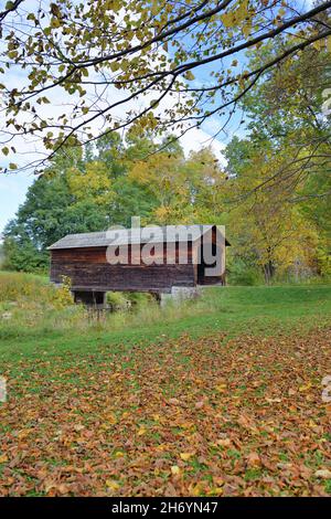 Cooperstown, New York, USA. Eine frühe Herbstansicht der Hyde Hall Covered Bridge über Shadow Brook. Die Brücke wurde 1825 gebaut. Stockfoto