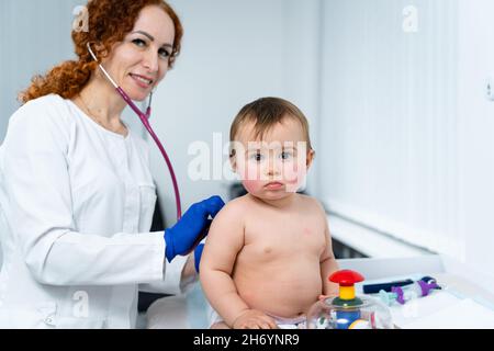 Kinderarzt Arzt Konzept. Medizinische Versorgung von Kindern. Ein Jahr altes Mädchen, das von einer Kinderärztin im Klinikbüro untersucht wurde. Kind besucht Arzt für Stockfoto