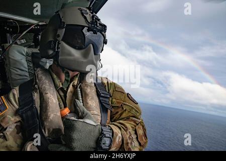 SPC der US-Armee. Brandon Richardson, ein UH-60-Hubschrauber-Reparaturer mit 2nd Bataillons, 25th Aviation Regiment, posiert für ein Foto auf einem UH-60-Blackhawk-Hubschrauber der US-Armee vor der Küste von Oahu, Hawaii, 15. November 2021. Die Qualifikation für die Landung von Deck wird jährlich durchgeführt, um die Kenntnisse zu erhalten, was fortgesetzte gemeinsame Operationen und Schulungen im gesamten Indo-Pazifik-Raum ermöglicht. (USA Armee-Foto von SPC. Matthew Mackintosh, 28th Public Affairs Detachment) Stockfoto