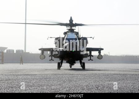 Ein AH-64E-Apache-Hubschrauber, der der Fort Bragg, North Carolina, mit Sitz in 82nd Combat Aviation Brigade, 82nd Airborne Division, zugewiesen wurde, landet am 10. November 2021 im Hafen von Shuaiba, Kuwait, in Vorbereitung auf einen retrograden Betrieb. Die 1100th Theatre Aviation Sustainment Maintenance Group mit Sitz in Aberdeen Proving Ground, Maryland, überwachte die Vorbereitungen für den Rückschritt von mehr als 30 Flugzeugen, die der CAB 82nd vom 7. Bis 12. November zugewiesen wurden. Die Soldaten und Flugzeuge wurden nach Afghanistan entsandt, um die Schließung von Stützstellen und den Ausstieg des US-Militärs vom Hamid Karzai International Airport in Kabul zu unterstützen. Stockfoto