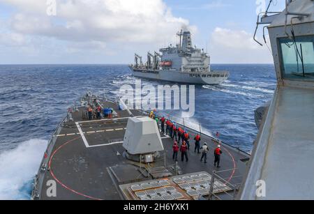 211117-N-SS432-1018 SÜDCHINESISCHES MEER (NOV 17, 2021) Seeleute an Bord des Arleigh Burke-Klasse-Lenkflugkörper-Zerstörers USS Chafee (DDG 90) bereiten sich mit dem Flottennachfüller USNS Yukon (T-AO 202) der Henry J. Kaiser-Klasse (17. November 2021) auf eine Aufstockung auf See vor. Chafee ist im geplanten Einsatzgebiet der US-Flotte für 7th im Einsatz, um die Interoperabilität durch Allianzen und Partnerschaften zu verbessern und gleichzeitig als einsatzbereite Kraft zur Unterstützung einer freien und offenen Region im Indo-Pazifik-Raum zu dienen. (USA Navy Foto von Mass Communication Specialist 1st Class Omar Powell) Stockfoto