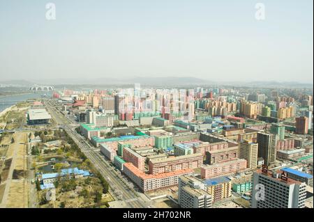 Der Blick auf die farbenfrohen Apartmentblöcke im Zentrum von Pjöngjang und den Taedong-Fluss von der Spitze des Juche-Turms in Nordkorea. Stockfoto